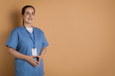 Professional nurse with badge on dark beige background. Space for text