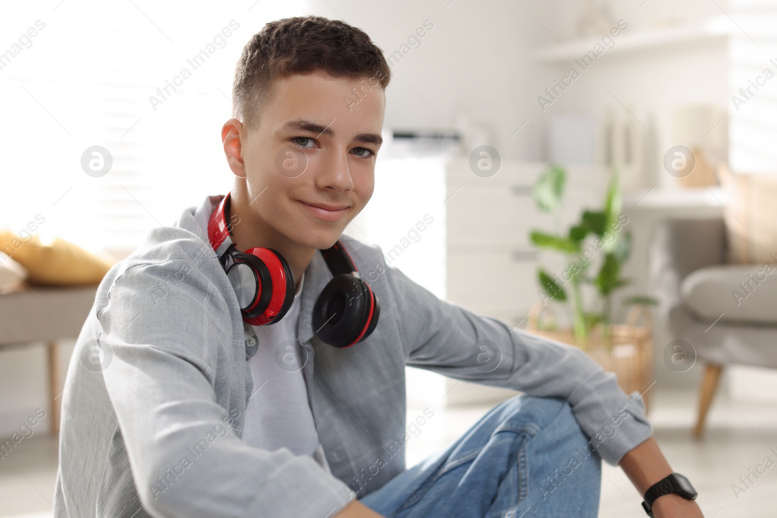 Photo of Portrait of teenage boy with headphones at home