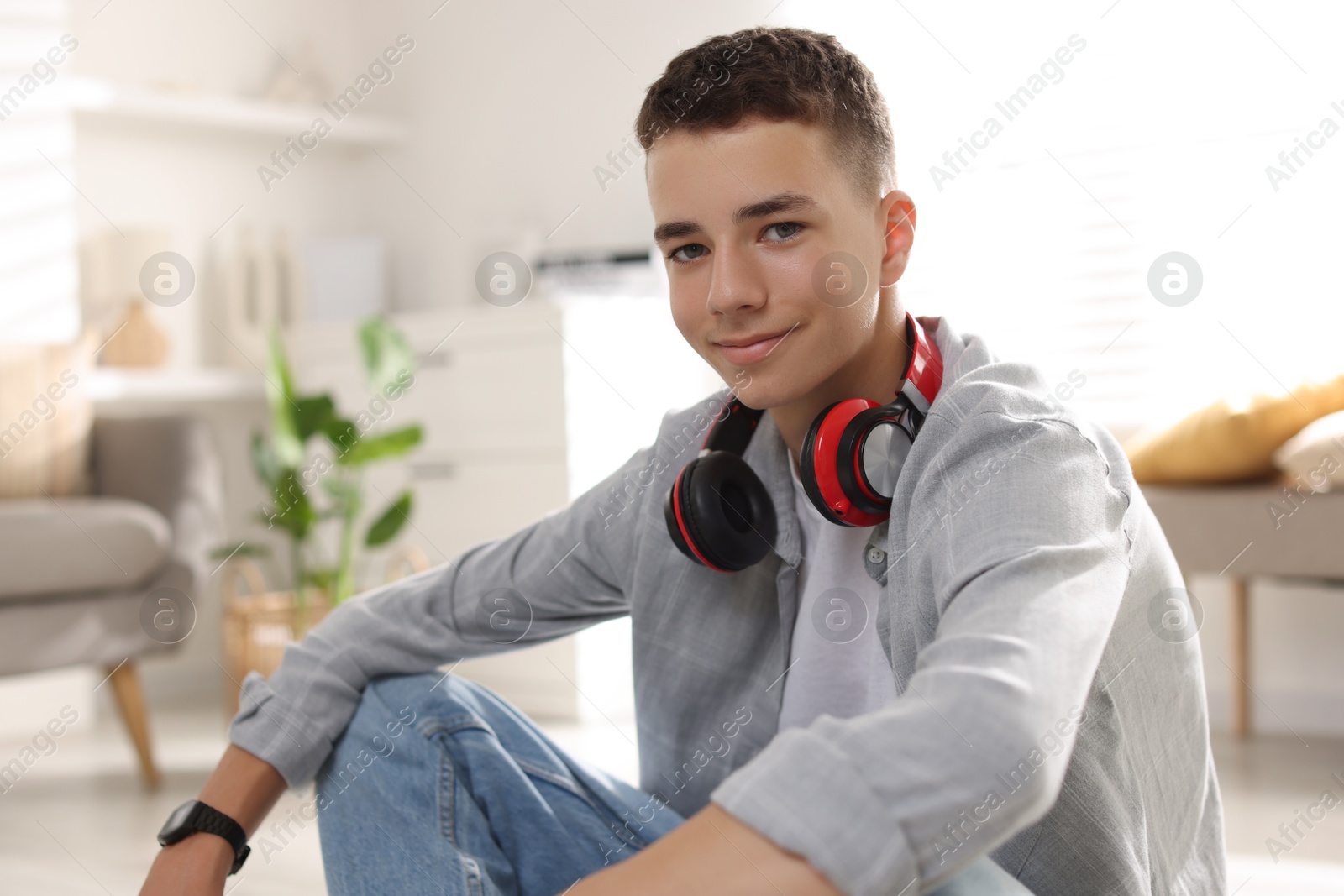 Photo of Portrait of teenage boy with headphones at home