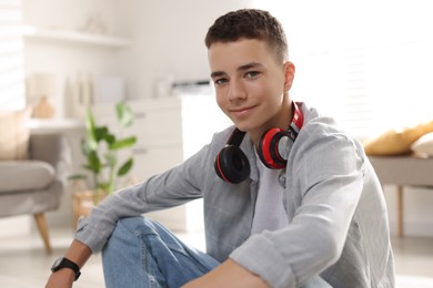 Photo of Portrait of teenage boy with headphones at home