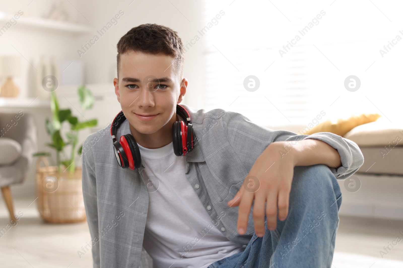 Photo of Portrait of teenage boy with headphones at home