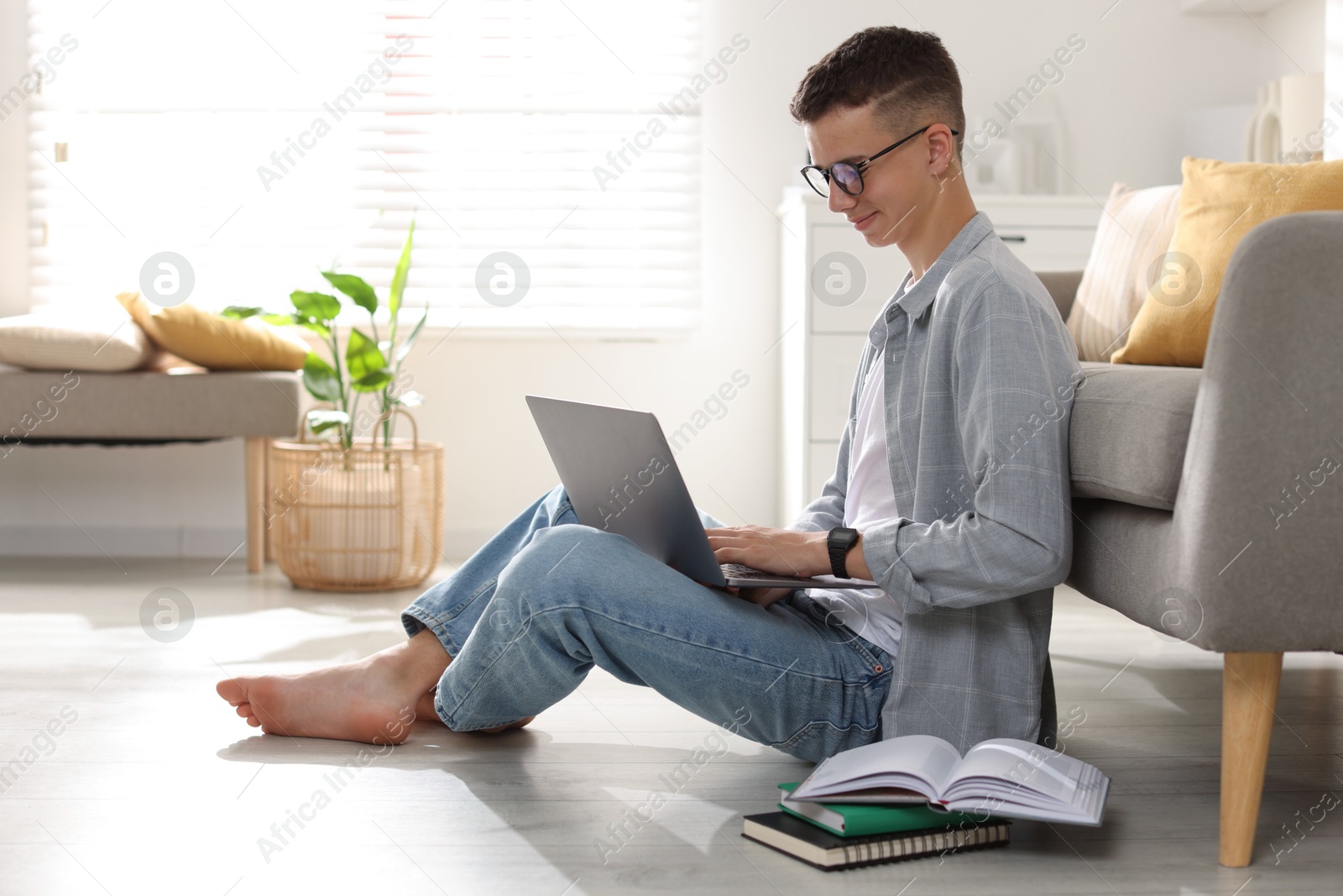 Photo of Full length portrait of teenage boy studying with laptop at home. Space for text