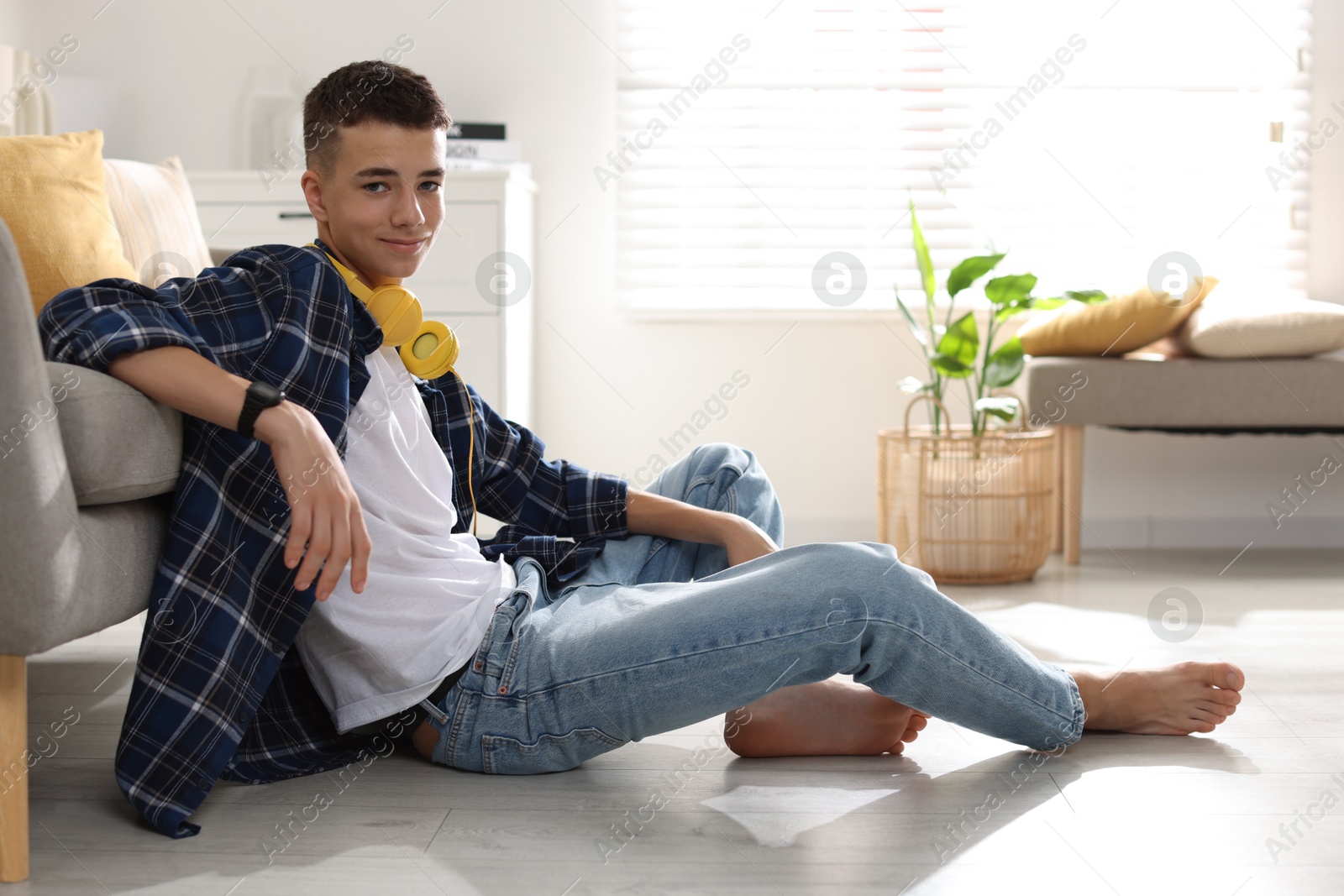 Photo of Full length portrait of teenage boy posing on floor at home. Space for text