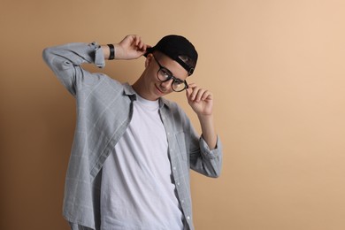 Photo of Portrait of teenage boy on dark beige background. Space for text