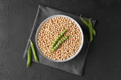 Dried peas and pods with fresh ones on dark textured table, top view