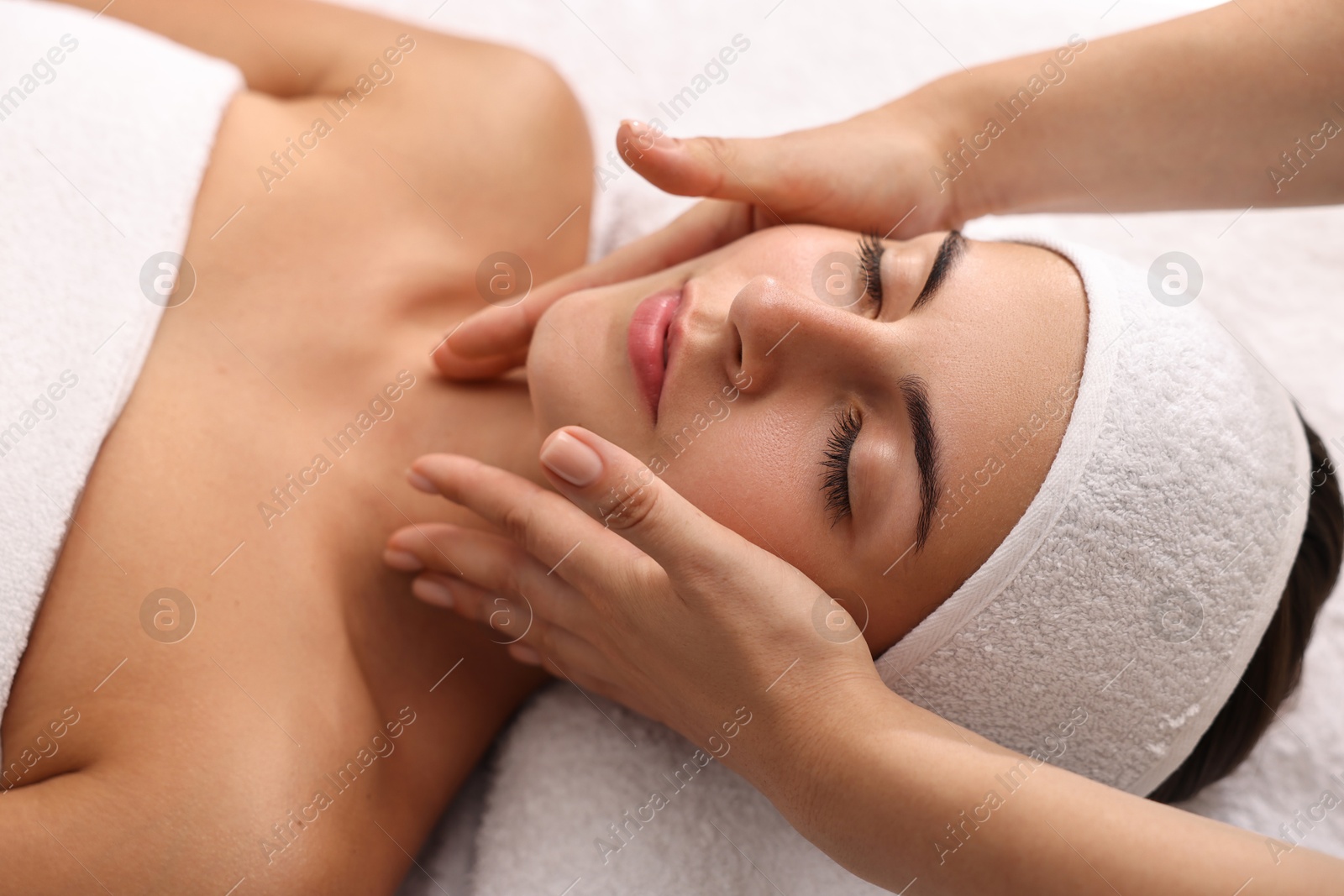 Photo of Attractive woman enjoying face massage, closeup. Beauty procedure