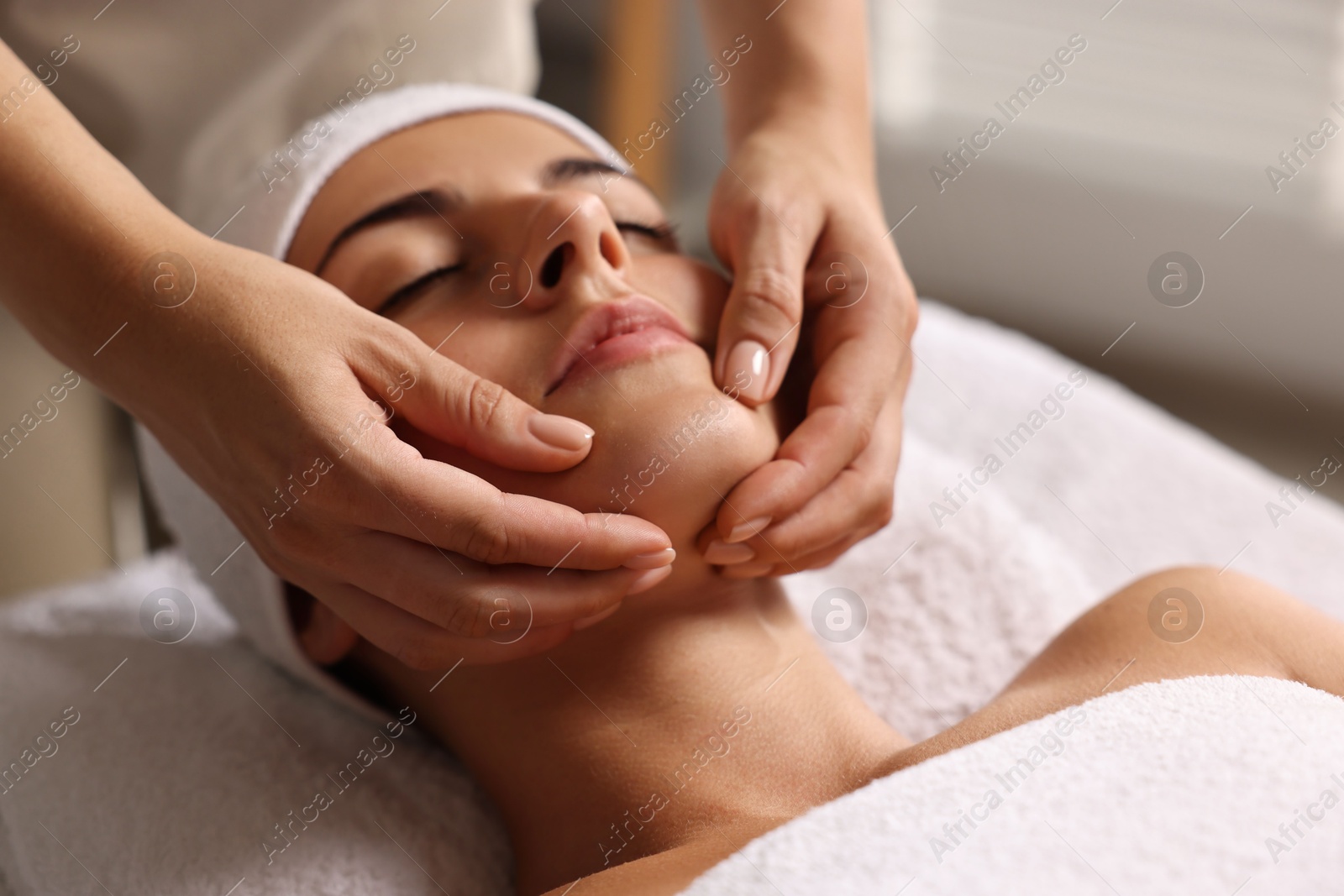 Photo of Attractive woman enjoying face massage, closeup. Beauty procedure