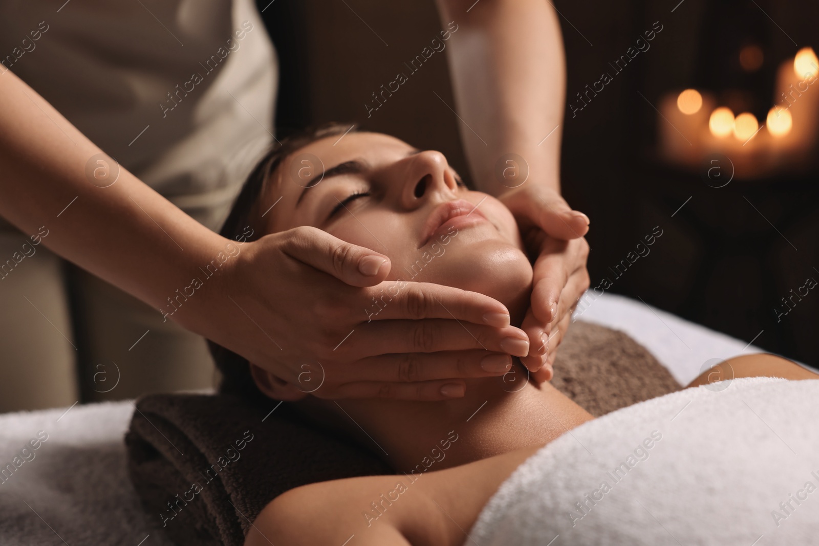 Photo of Attractive woman enjoying face massage, closeup. Beauty procedure