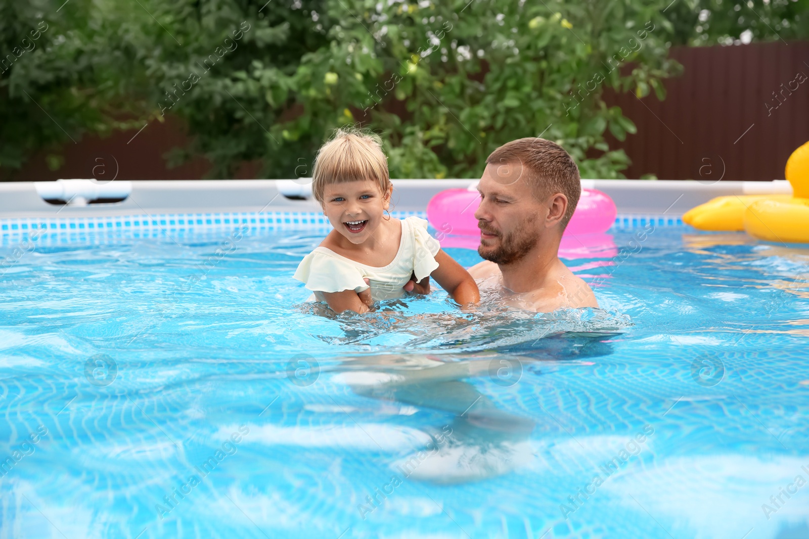 Photo of Happy daughter and her father having fun in swimming pool