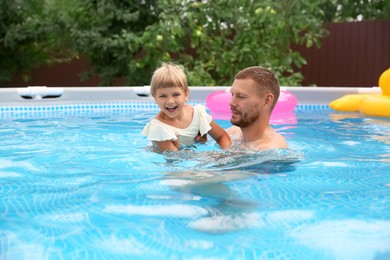 Photo of Happy daughter and her father having fun in swimming pool