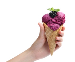 Woman holding wafer cone with delicious blackberry sorbet on white background, closeup