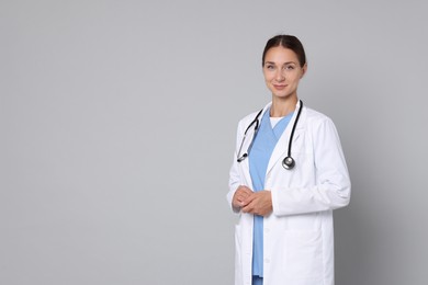 Photo of Nurse in medical uniform with stethoscope on grey background, space for text