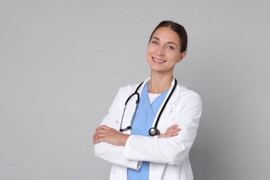 Photo of Nurse in medical uniform with stethoscope on grey background, space for text