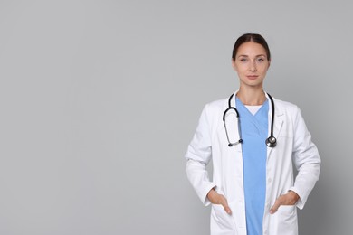 Photo of Nurse in medical uniform with stethoscope on grey background, space for text