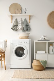 Photo of Washing machine and towels in laundry room