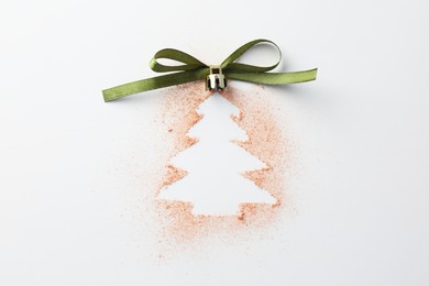 Photo of Christmas ball in shape of tree made of powder and bow on white background, top view