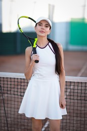 Beautiful woman with tennis racket on court