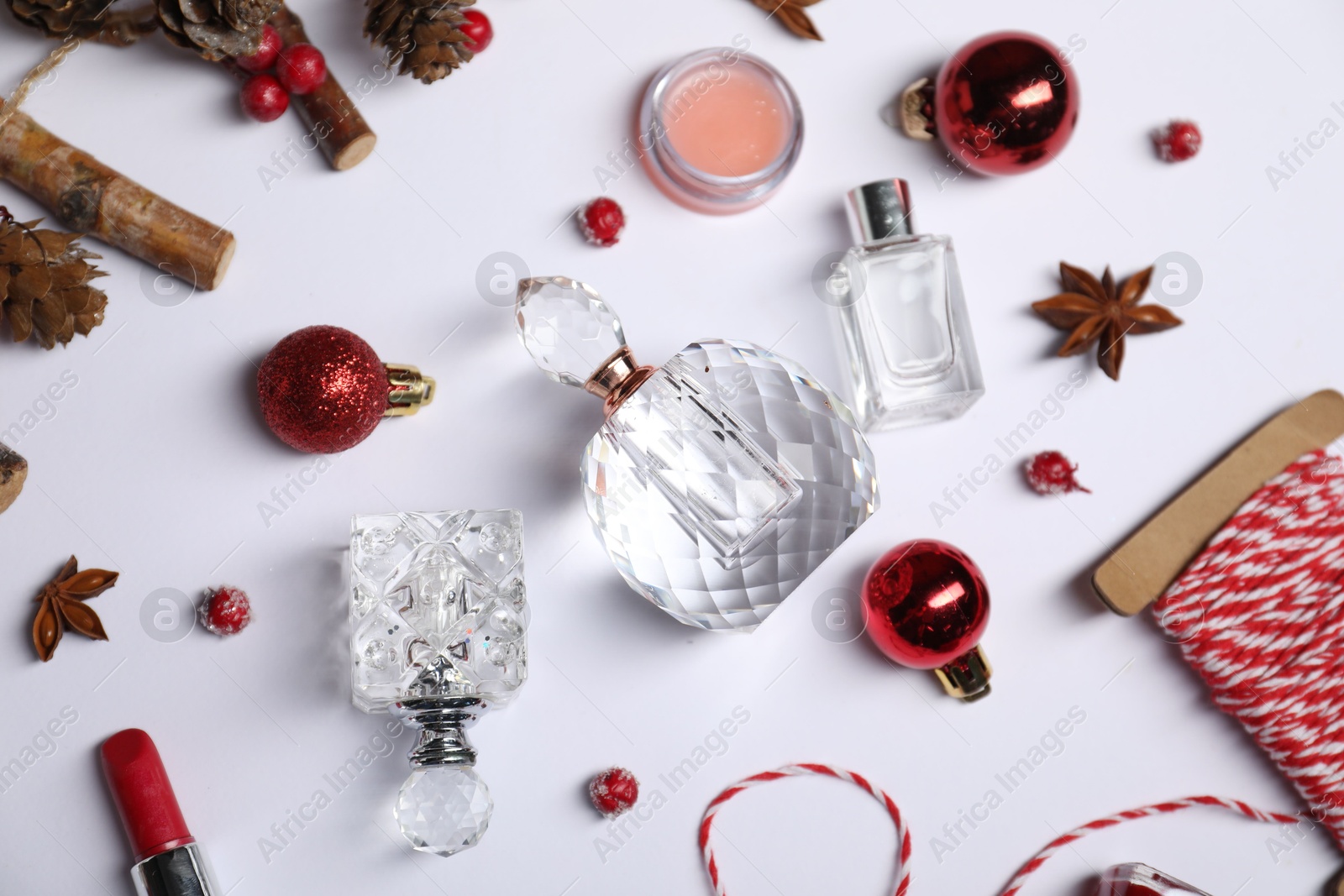 Photo of Christmas composition with perfume bottles on white background, flat lay