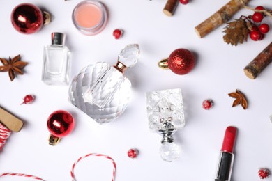 Photo of Christmas composition with perfume bottles on white background, flat lay