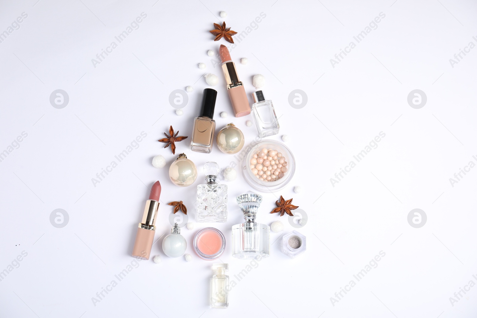 Photo of Christmas tree shape made of perfume bottles and cosmetic products on white background, flat lay