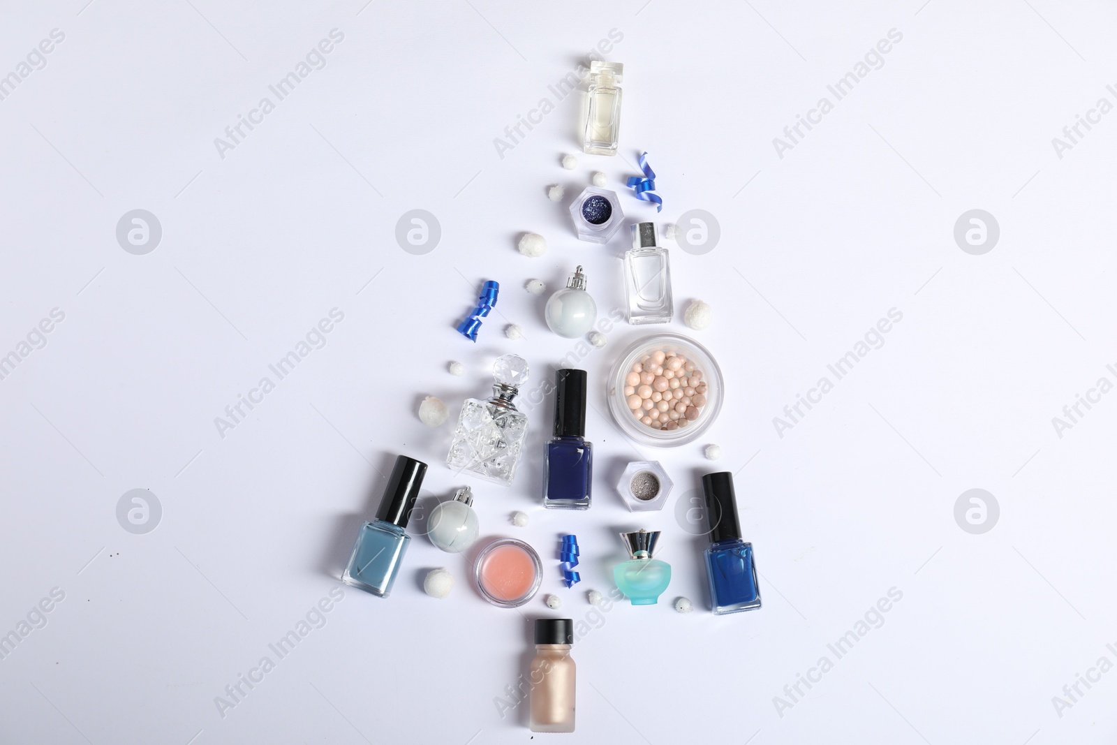 Photo of Christmas tree shape made of perfume bottles and cosmetic products on white background, flat lay