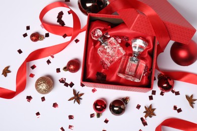 Christmas composition with perfume bottles on white background, flat lay