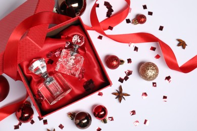 Photo of Christmas composition with perfume bottles on white background, flat lay