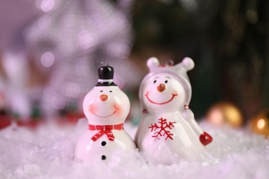 Photo of Funny snowmen figures on artificial snow, closeup