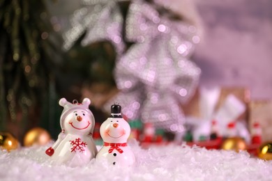 Photo of Funny snowmen figures on artificial snow, space for text