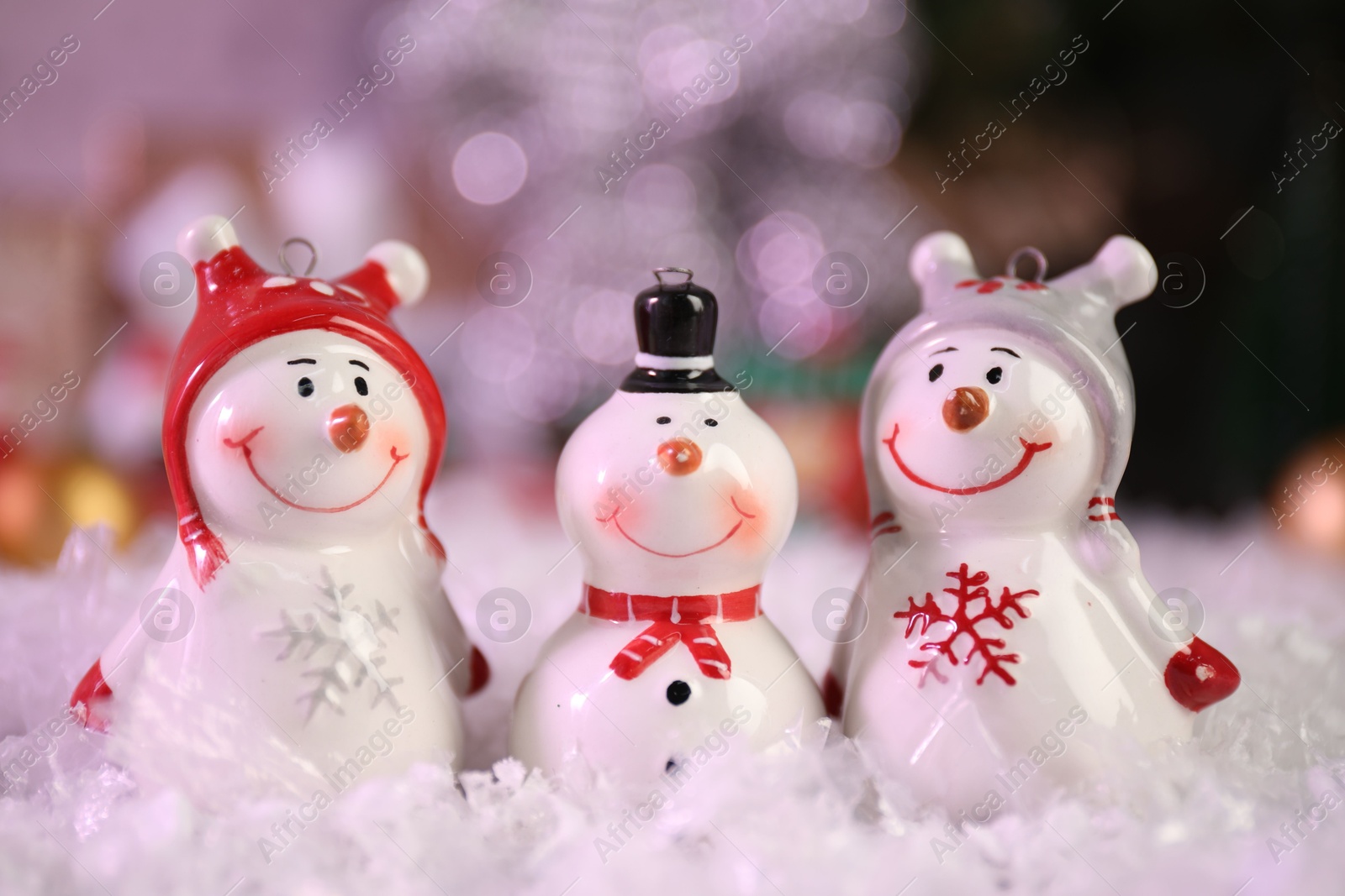 Photo of Funny snowmen figures on artificial snow, closeup