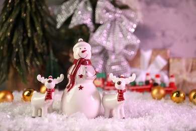 Photo of Funny snowman figure and deers on artificial snow