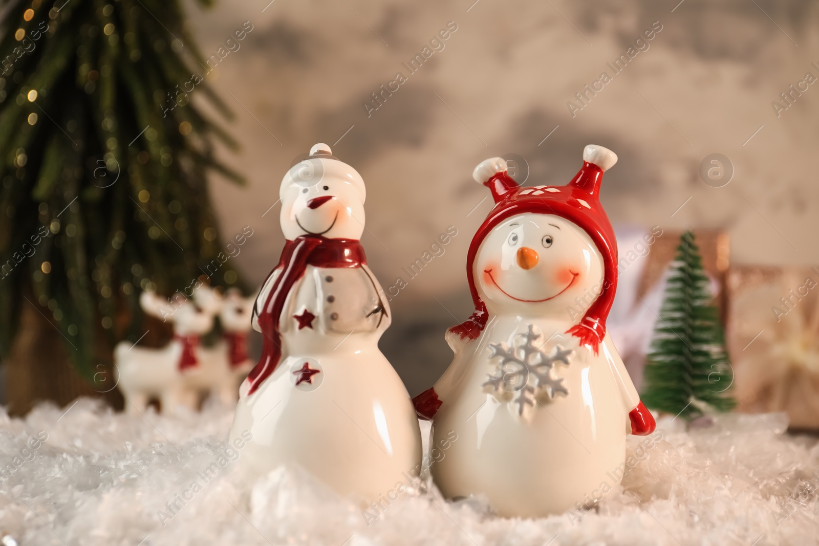 Photo of Funny snowmen figures on artificial snow, closeup