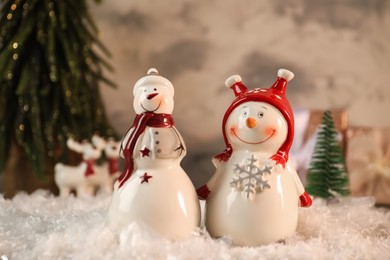 Photo of Funny snowmen figures on artificial snow, closeup