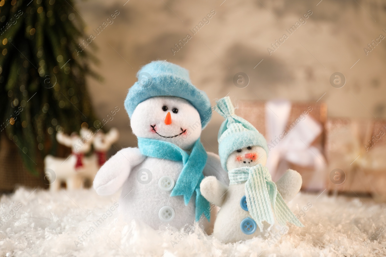 Photo of Funny snowmen figures on artificial snow, closeup