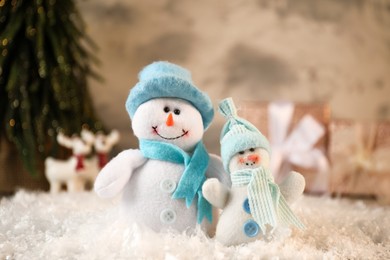 Photo of Funny snowmen figures on artificial snow, closeup