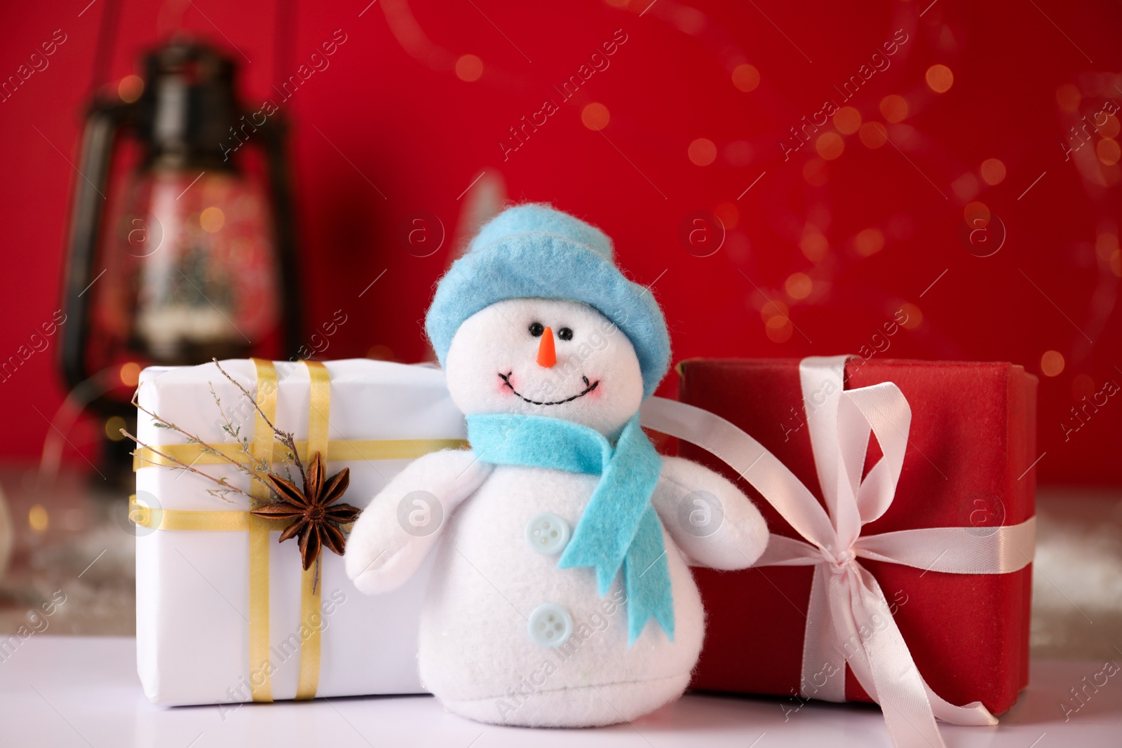 Photo of Funny snowman figure and Christmas gifts on white table