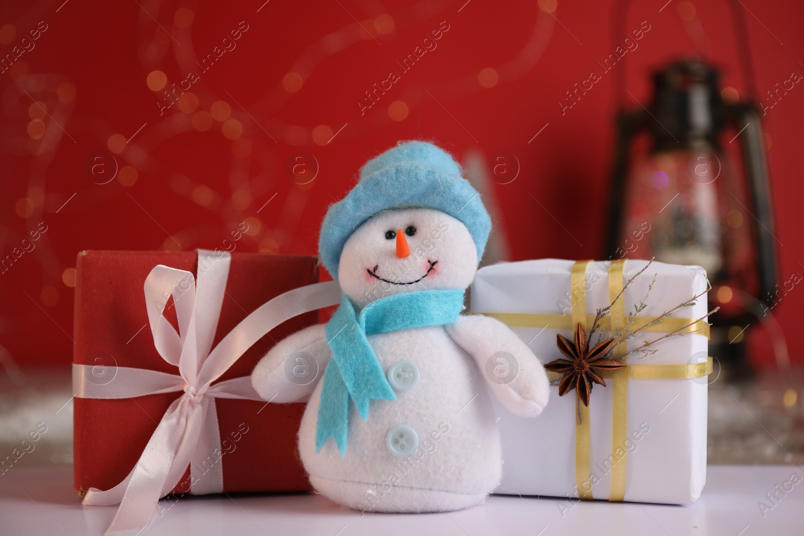 Photo of Funny snowman figure and Christmas gifts on white table