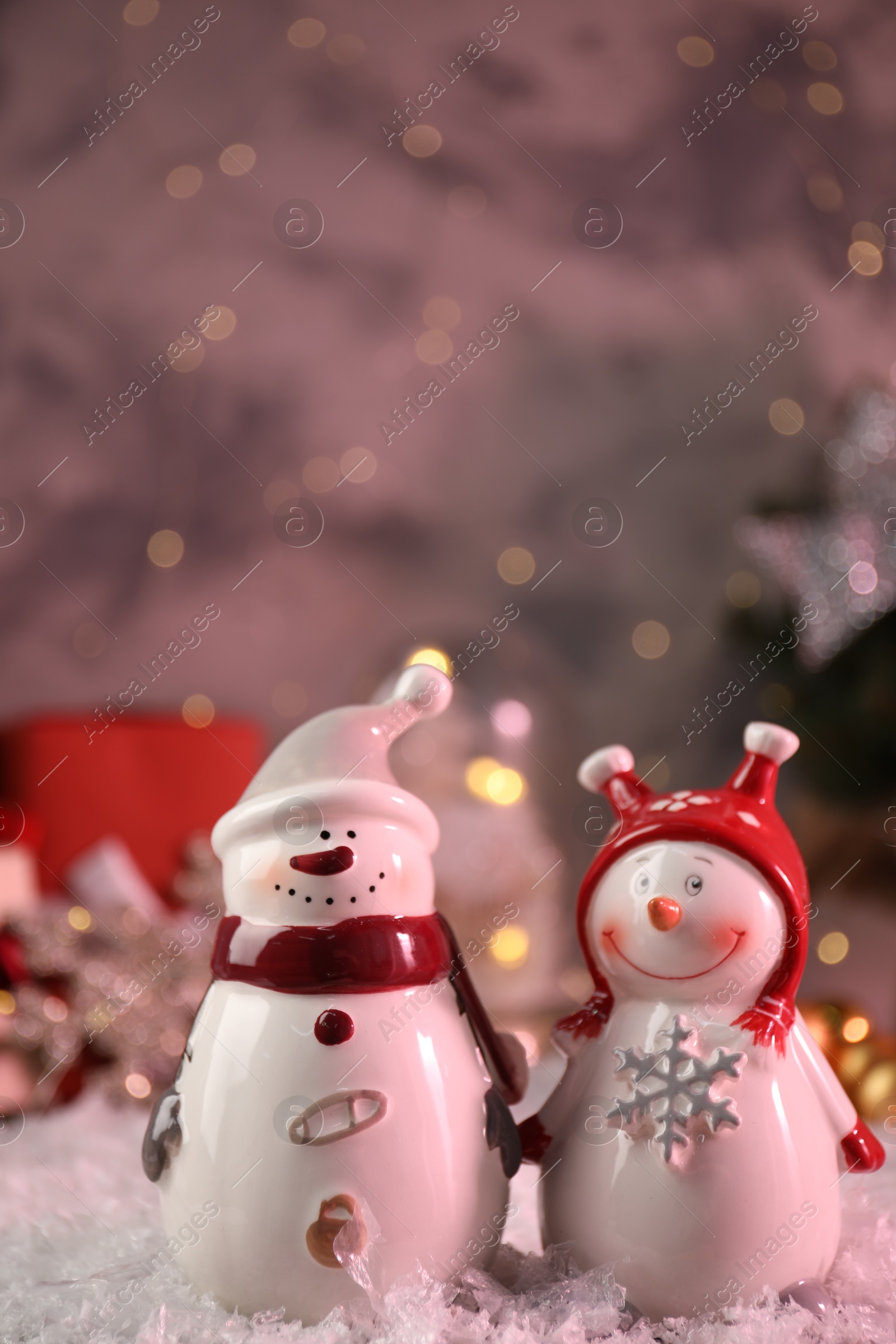 Photo of Funny snowmen figures in hats on artificial snow