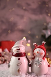 Photo of Funny snowmen figures in hats on artificial snow