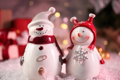 Photo of Funny snowmen figures on artificial snow, closeup