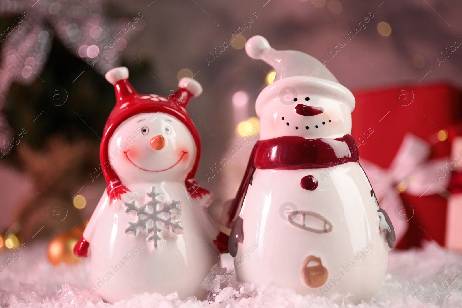 Photo of Funny snowmen figures on artificial snow, closeup