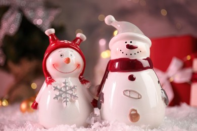 Photo of Funny snowmen figures on artificial snow, closeup