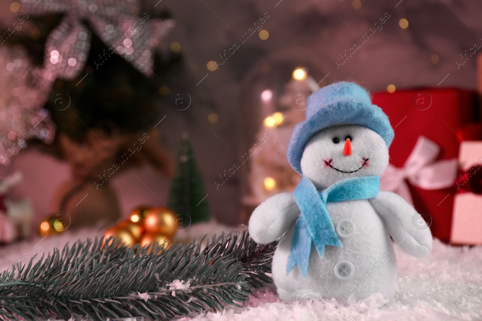 Photo of Funny snowman figure and fir branch on artificial snow