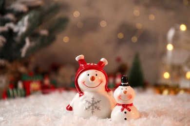 Photo of Funny snowmen figures on artificial snow, closeup