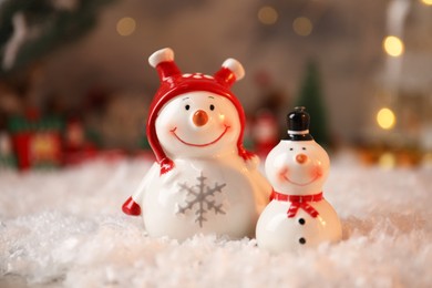 Photo of Funny snowmen figures on artificial snow, closeup