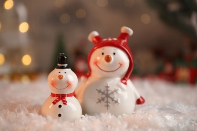 Photo of Funny snowmen figures on artificial snow, closeup