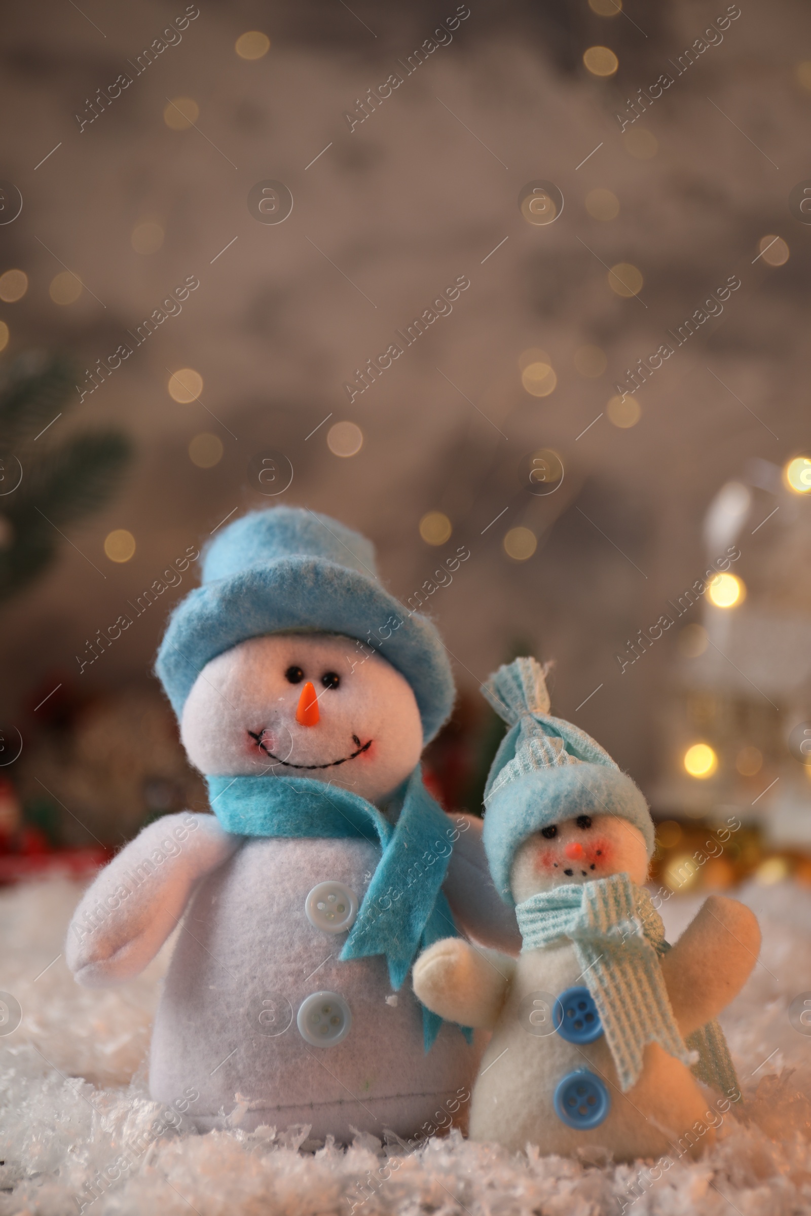 Photo of Funny snowmen figures on artificial snow, closeup