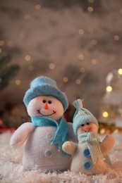 Photo of Funny snowmen figures on artificial snow, closeup