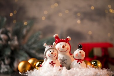 Photo of Funny snowmen figures and Christmas decor on table