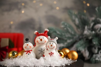 Photo of Funny snowmen figures and Christmas decor on table